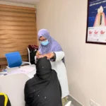 Dr. Tasmia performing oral examination and consultation with female patient in dental office