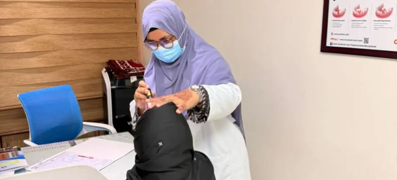 Dr. Tasmia performing oral examination and consultation with female patient in dental office