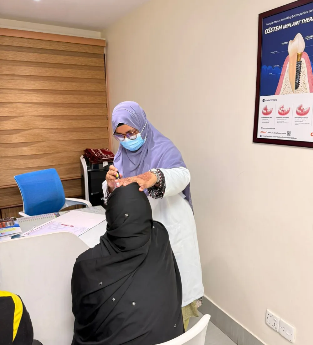 Dr. Tasmia performing oral examination and consultation with female patient in dental office