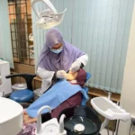 Dr. Tasmia performing dental procedure on patient in chair using professional equipment